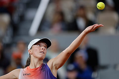 Iga Swiatek serves against Naomi Osaka